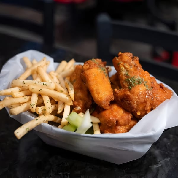 A basket of Jams@209 Sports Bar & Grill's crispy chicken wings and golden french fries.