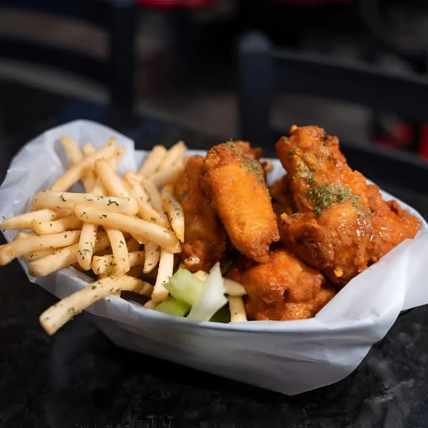 A basket of Jams@209 Sports Bar & Grill's crispy chicken wings and golden french fries.