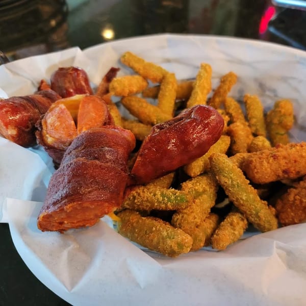 Close-up of Jams@209 Sports Bar & Grill's fried green beans and bacon-wrapped sausages in a basket.