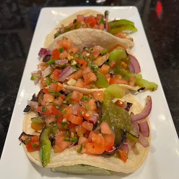 Three Jams@209 Sports Bar & Grill tacos with salsa, green peppers, and red onions on a white plate.